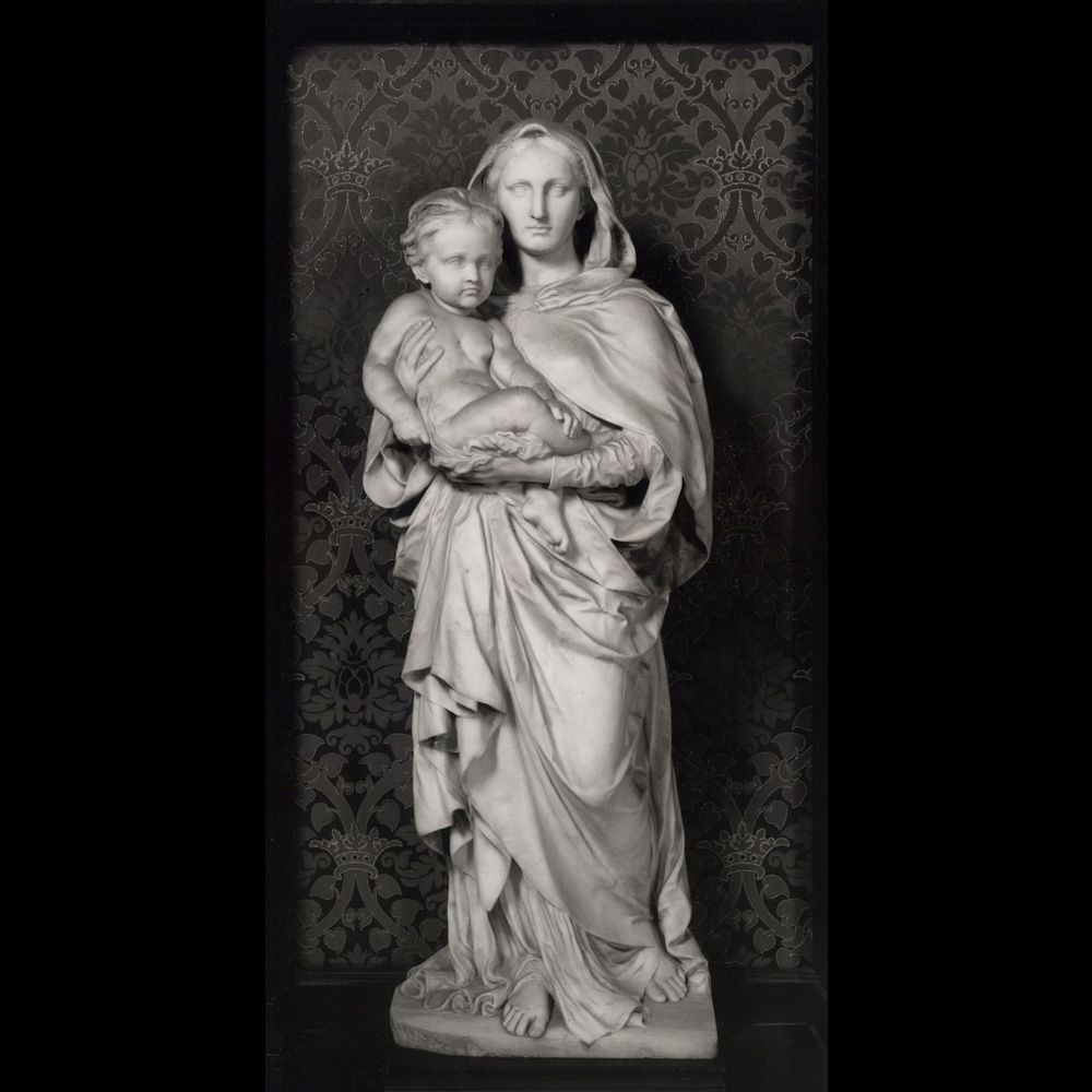 sculpture of a woman wearing long robes, holding a very young child