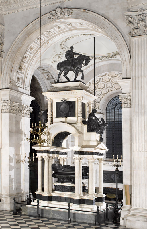 Marble and bronze monument: full-size man on a borse at the top and a recumbent figure at the bottom, under a marble canopy